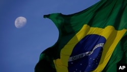 La bandera brasileña ondea con la Luna de fondo durante una protesta en Brasilia, el 24 de enero de 2021.