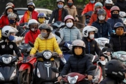Labourers wearing protective masks wait for a ferry on the way home after work, despite a government rule on social distancing during the coronavirus outbreak in Hai Duong province, Vietnam, April 7, 2020.
