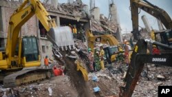 Workers and army personnel use heavy machinery as they work to clear the site and recover bodies of victims from the rubble of a garment factory building collapse in Savar near Dhaka, Bangladesh, May 6, 2013..