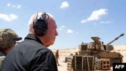 Menteri Pertahanan Israel Yoav didampingi para tentara berdiri di samping artileri Howitzer saat mengunjungi posisi pasukan Israel di sepanjang perbatasan dengan Jalur Gaza di selatan Israel, Selasa, 7 Mei 2024. (Foto: Militer Israel via AFP)