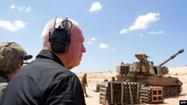 Menteri Pertahanan Israel Yoav didampingi para tentara berdiri di samping artileri Howitzer saat mengunjungi posisi pasukan Israel di sepanjang perbatasan dengan Jalur Gaza di selatan Israel, Selasa, 7 Mei 2024. (Foto: Militer Israel via AFP)
