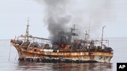 In this photo provided by the U.S. Coast Guard, a plume of smoke rises from the derelict Japanese ship Ryou-Un Maru after it was hit by canon fire by a U.S. Coast Guard cutter in the Gulf of Alaska, April 5, 2012.