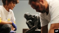 Staff members prepare to move Rodin's The Thinker bronze statue during installation at the Louvre Museum in Abu Dhabi, United Arab Emirates, Oct. 27, 2019. The statue created in the 1880s is a one-year loaner from Rodin Museum in France.