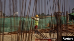FILE - A man works at the site of the Thilawa Special Economic Zone (SEZ) project at Thilawa, Myanmar, May 8, 2015. 