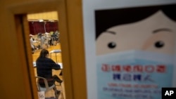 香港一所学校的教室外张贴着要求学生戴口罩防止新冠病毒的宣传画。（2020年4月24日）