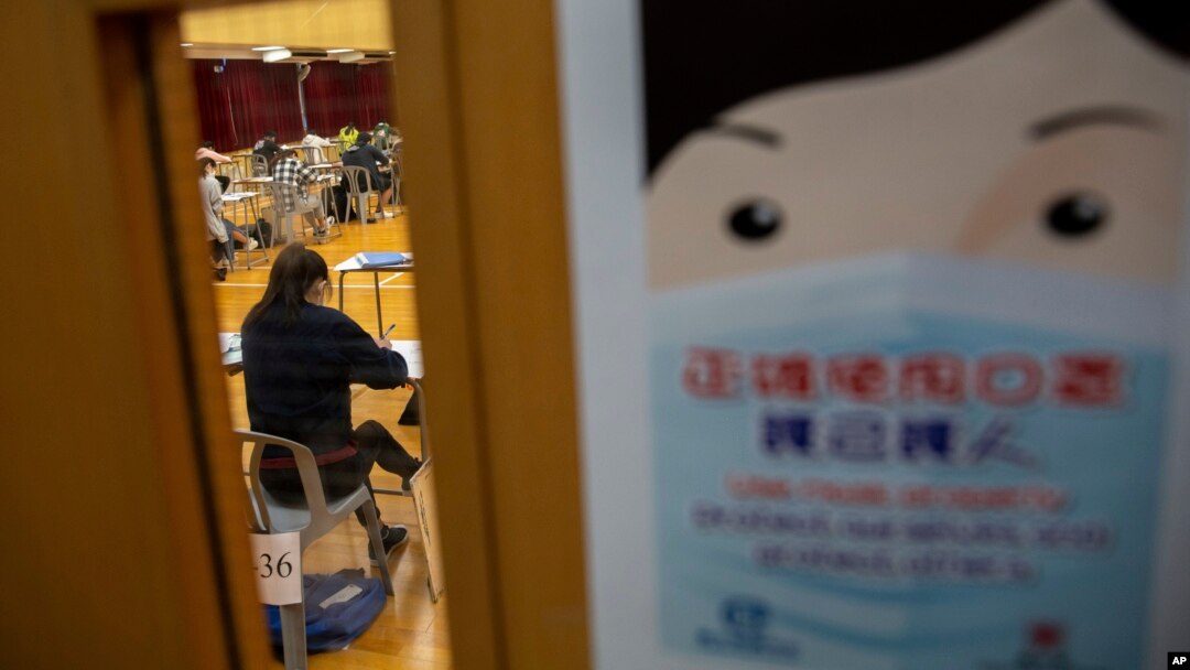 Poster yang mewajibkan siswa memakai masker untuk meneken penyebaran virus Covid-19 dipasang di luar kelas sekolah Hong Kong, 24 April 2020. (Foto: dok).