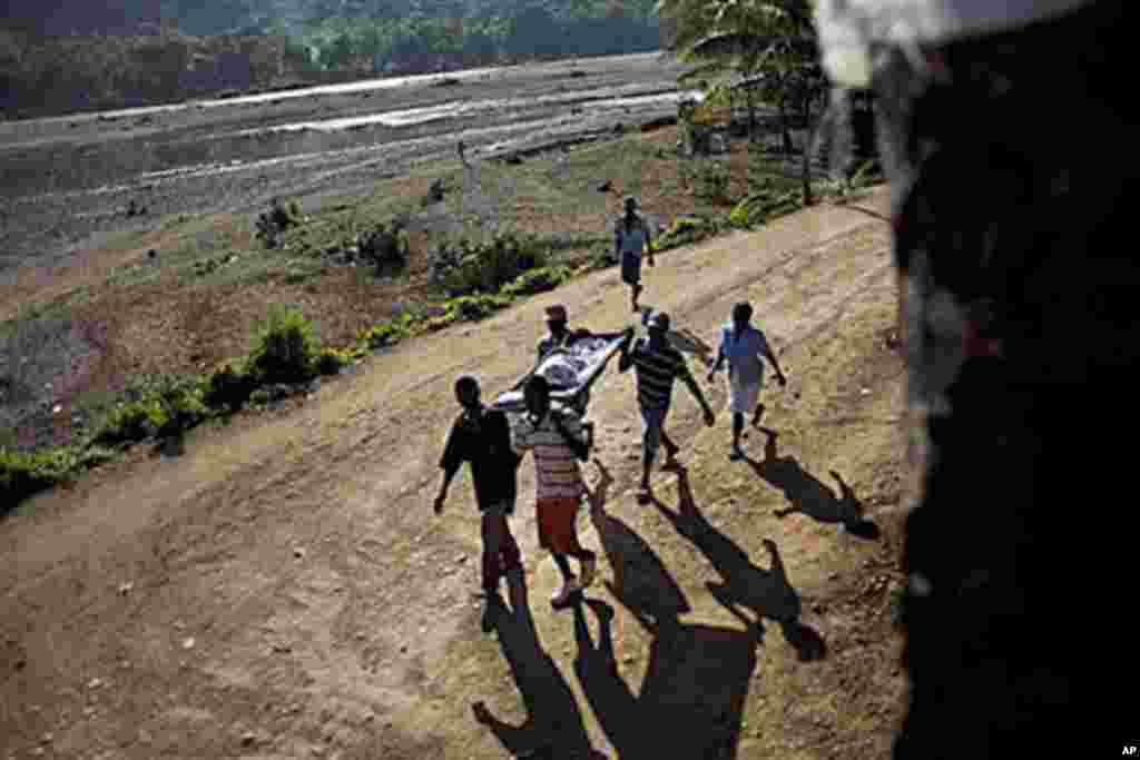 Michelet Compere, 14, suffering from cholera, is carried on a stretcher by relatives during their four-hour journey from a remote village in Pond Chevalier to the hospital in Grande Riu Du Nord village, Haiti, Nov 29, 2010