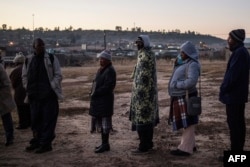 Voters queue outside a polling station in order to cast their ballot during the Lesotho's general elections on June 3, 2017 in Maseru.