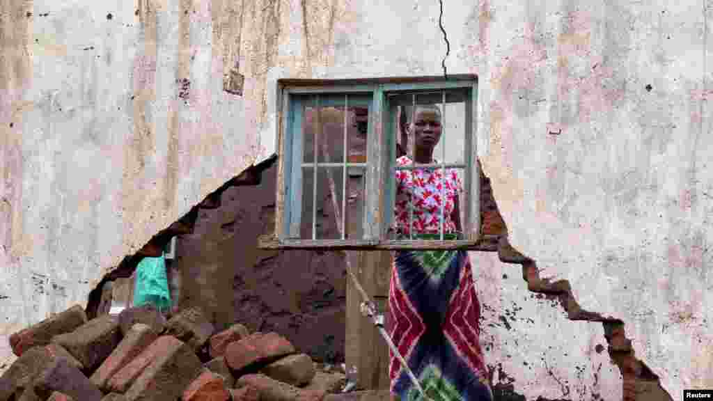 A woman looks at her house that was destroyed by Tropical Storm Ana at Kanjedza village, in Chikwawa district, Malawi, Jan. 26, 2022.