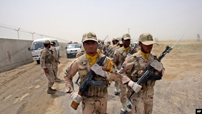 FILE - A group of Iranian border guards march at the eastern border of Iran shared with Pakistan and Afghanistan, near Zabol, Sistan-Baluchistan Province, Iran, July 19, 2011.