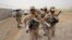 FILE - A group of Iranian border guards march at the eastern border of Iran shared with Pakistan and Afghanistan, near Zabol, Sistan-Baluchistan Province, Iran, July 19, 2011.