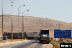 Commercial Turkish trucks wait to cross to Syria near the Cilvegozu border gate, located opposite the Syrian commercial crossing point Bab al-Hawa in Reyhanli, Hatay province, Turkey, Sept. 16, 2016.