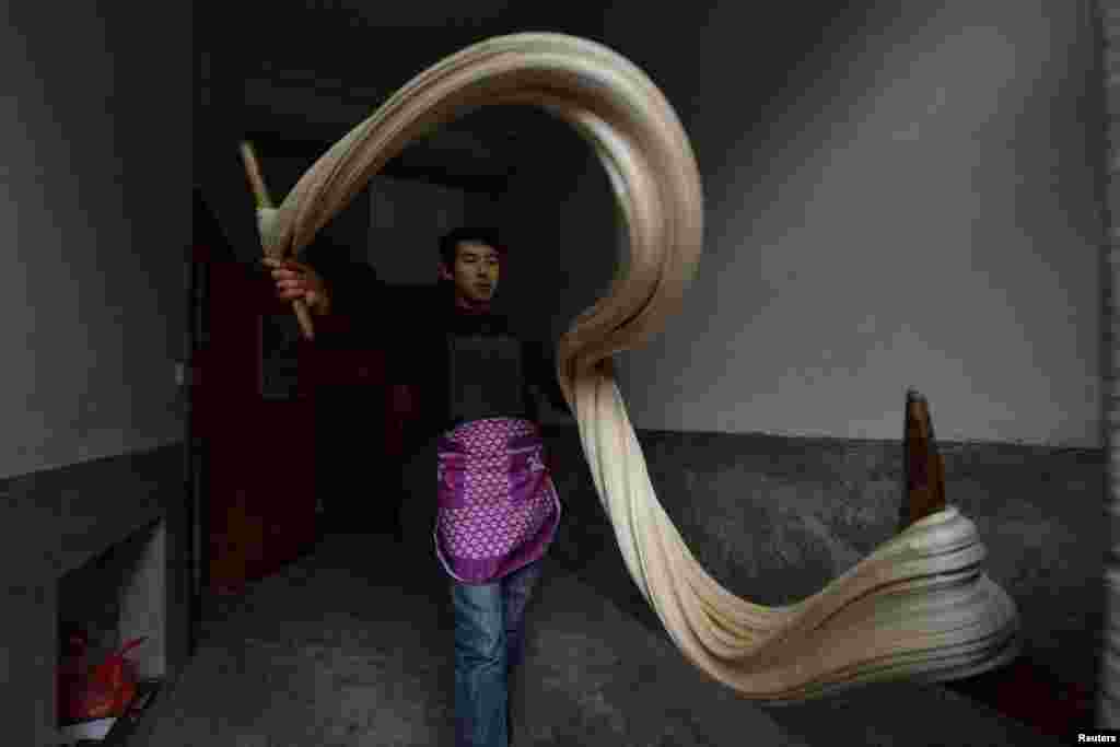 បុរសម្នាក់ធ្វើស្ករគ្រាប់ប្រពៃណីឈ្មោះ Matang ដើម្បីត្រៀមទទួលឆ្នាំថ្មីរបស់ចិននៅក្នុងតំបន់ Yuqing ក្រុង Zunyi ខេត្ត Guizhou ប្រទេសចិន កាលពីថ្ងៃទី១៨ ខែមករា ឆ្នាំ២០១៦។
