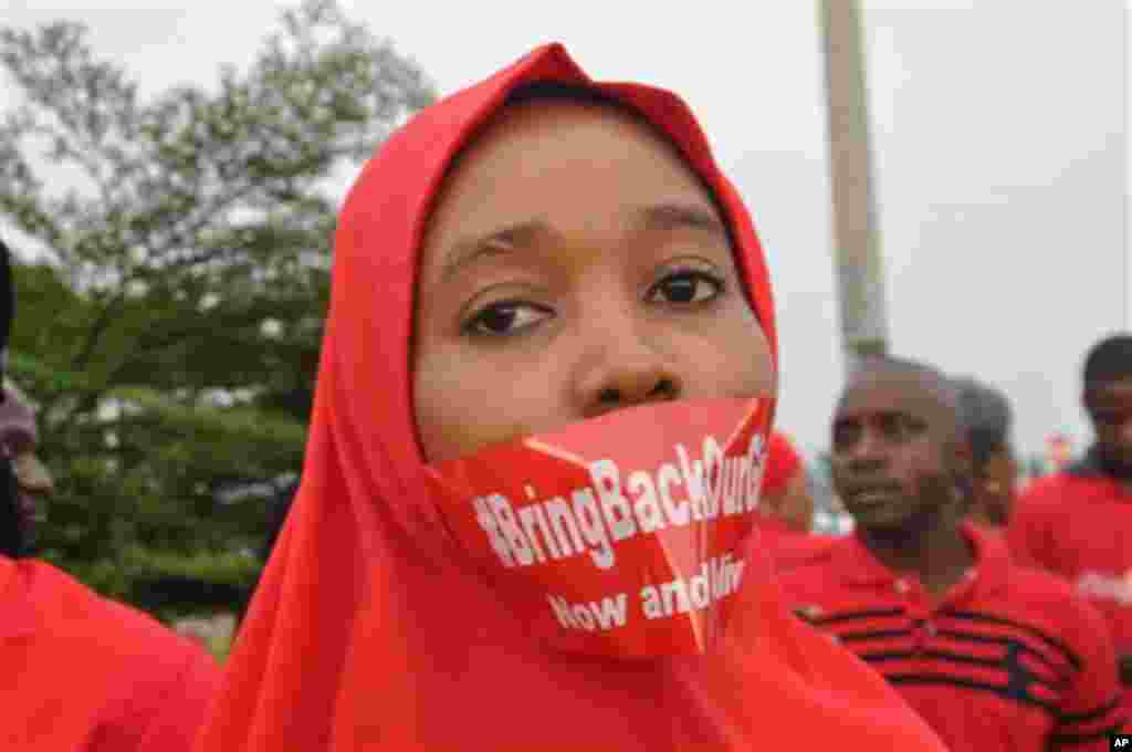 Une femme suit une manifestation à Abuja, au Nigeria, le jeudi 11 septembre 2014, demandant au gouvernement de sauver les jeunes filles enlevées de l&#39;école secondaire publique dans Chibok. (AP Photo / Olamikan Gbemiga) 