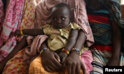 A woman holds her child as they wait to receive treatment in Kobo health center in Kobo village, one of the drought stricken areas of Oromia region, in Ethiopia, April 28, 2016.