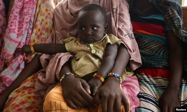 A woman holds her child as they wait to receive treatment in Kobo health center in Kobo village, one of the drought stricken areas of Oromia region, in Ethiopia, April 28, 2016.