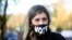 A woman wears a mask with a sign "VOTE" 