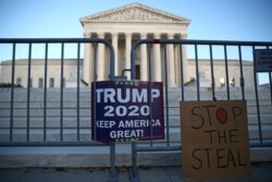 Signs by supporters of U.S. President Donald Trump hang outside the U.S. Supreme Court building in Washington, Nov. 10, 2020.