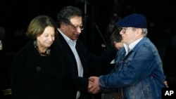 Rodrigo Londoño, presidente del partido COMUNES y excomandante de las FARC (der) estrecha la mano del presidente de Colombia, Gustavo Petro, durante una ceremonia por los 8 años del acuerdo de paz entre el gobierno y las FARC en Bogotá, Colombia, el 21 de noviembre de 2024.