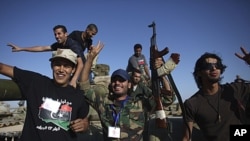 NTC fighters celebrate after capturing an armored vehicle in Wadi Dinar, Libya, Sept. 21, 2011.