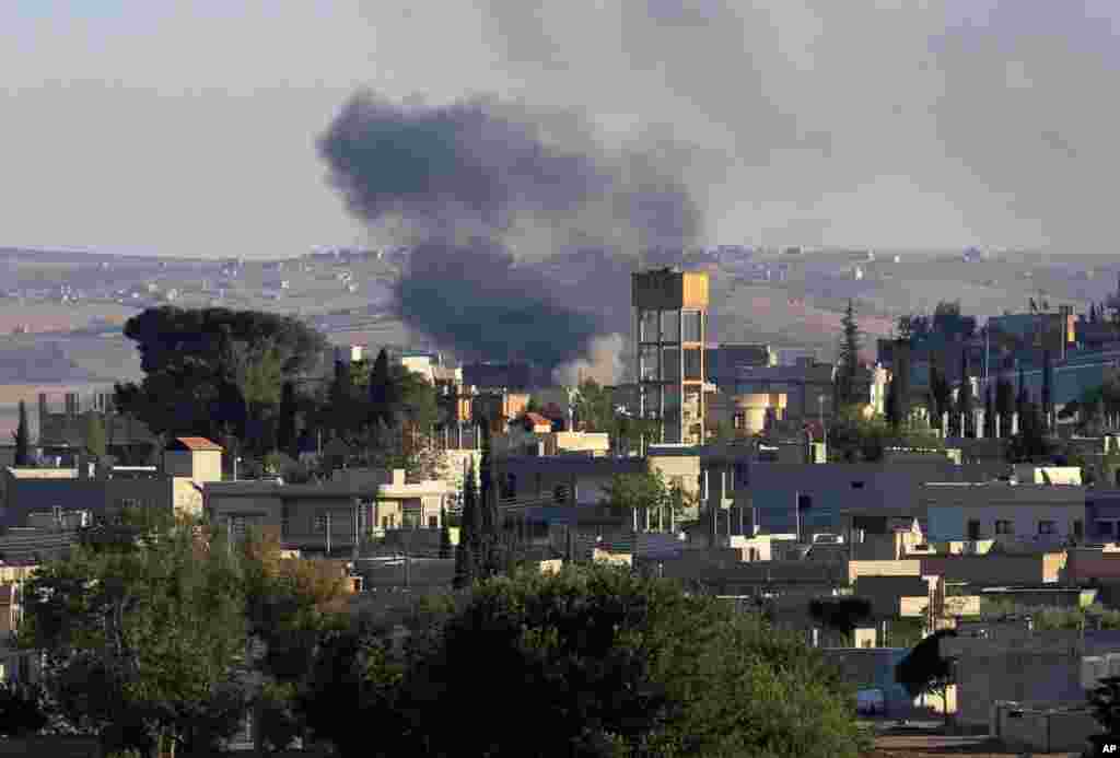 Smoke rises after a mortar shell landed south of Kobani, seen from the Turkish side of border as thousands of new Syrian refugees from Kobani arrive in Suruc, Turkey, Oct. 1, 2014. 