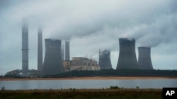 FILE - The coal-fired Plant Scherer is shown in operation June 1, 2014, in Juliette, Ga. A survey across 40 countries around the world found most people see global warming as a serious problem.