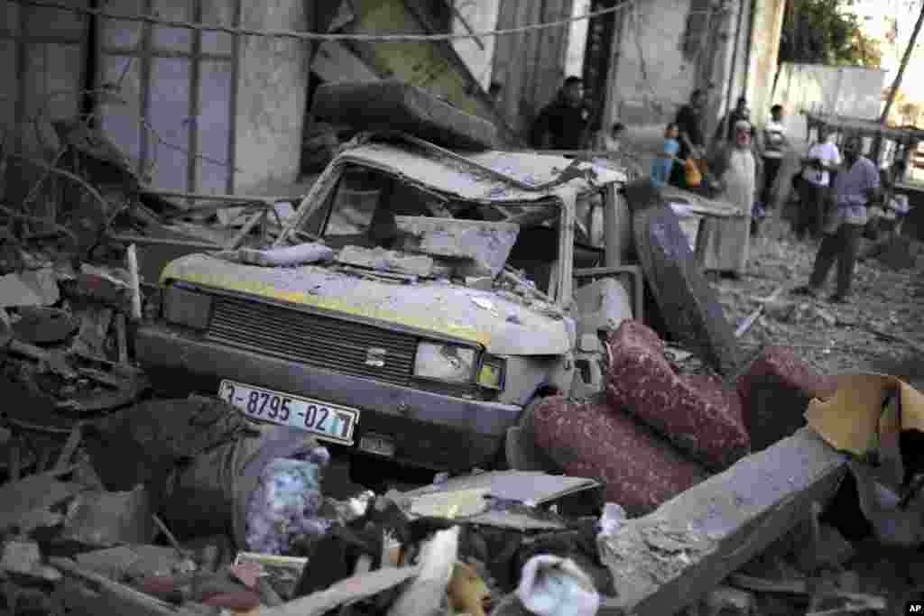 Palestinians inspect the damage caused by an early morning Israeli missile strike in Gaza City, July 16, 2014.