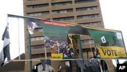 FILE - An old ripped election banner bearing a portrait of ousted President Robert Mugabe hangs outside the headquarters of the ruling ZANU PF building in Harare, Nov. 19, 2017.
