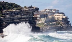 Ombak besar menghantam bebatuan di garis pantai di Bronte Beach di pinggiran timur Sydney, Australia, Senin, 12 April 2021. (AP Photo / Mark Baker)