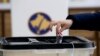 Kosovo, Pristina, A voter casts a ballot during parliamentary elections