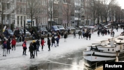 People ice skate during a cold snap across the country at the Prinsengracht in Amsterdam, Netherlands February 14, 2021. (REUTERS/Eva Plevier)