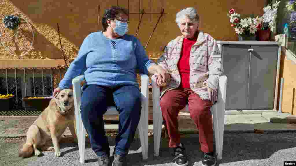 Gertrude Fatton, ha tratado de retomar su rutina, en esta foto posa con su hija Jacqueline fuera de su casa, en Le Locle, Suiza, después de su regreso del hospital tras haber sido ingresada por contagiarse de coronavirus.