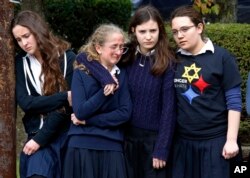 Los estudiantes de la Escuela Yeshiva en el vecindario de Squirrel Hill en Pittsburgh presentan sus respetos mientras la procesión funeraria del doctor Jerry Rabinowitz pasa por su escuela en ruta al cementerio de Homewood después de un funeral en el Centro Comunitario Judío. Pittsburgh, Pensilvania, octubre 30 de 2018.