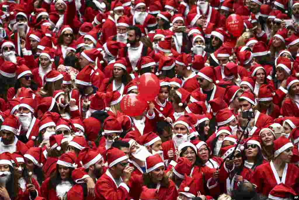 People wearing Santa Claus costumes gather to take part in the 2016 Athens Santa Run in Athens, Greece.