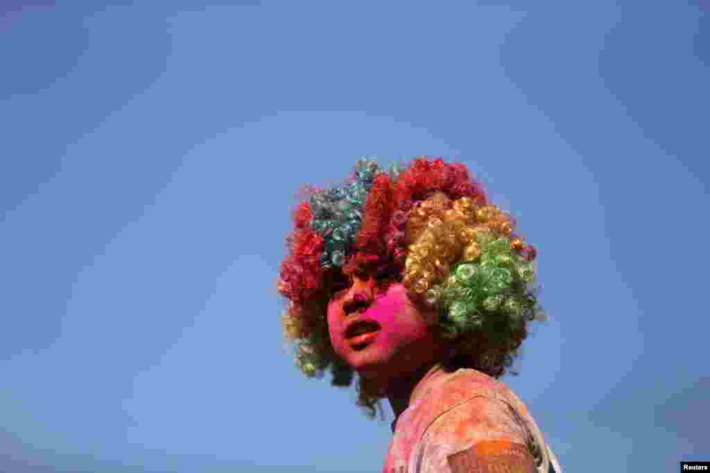 Seorang anak kecil yang memakai wig warna-warni menonton lomba lari 5K (5 kilometer) di Centennial Park di kota Sydney, Australia.