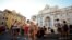 Transeúntes y turistas con máscaras junto a la Fuente de Trevi, una de las principales atracciones de Roma.