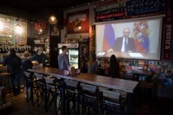 25일 러시아 모스크바의 한 술집에서 손님들이 블라디미르 푸틴 대통령의 TV 연설 중계를 보고 있다.