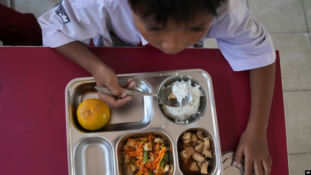 Seorang siswa sekolah dasar di Depok, Jawa Barat, menikmati makanannya saat peluncuran program makanan gratis, 6 Januari 2025. (Dita Alangkara/AP)