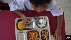 Seorang siswa sekolah dasar di Depok, Jawa Barat, menikmati makanannya saat peluncuran program makanan gratis, 6 Januari 2025. (Dita Alangkara/AP)