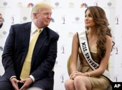 FILE - Donald Trump, left, appears with 2014 Miss Universe, Venezuela's Gabriela Isler. Univision has dropped the pageant.