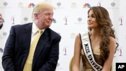 FILE - Donald Trump (L) and 2014 Miss Universe, Gabriela Isler, of Venezuela, talk during a news conference Oct. 2, 2014, in Doral, Florida.