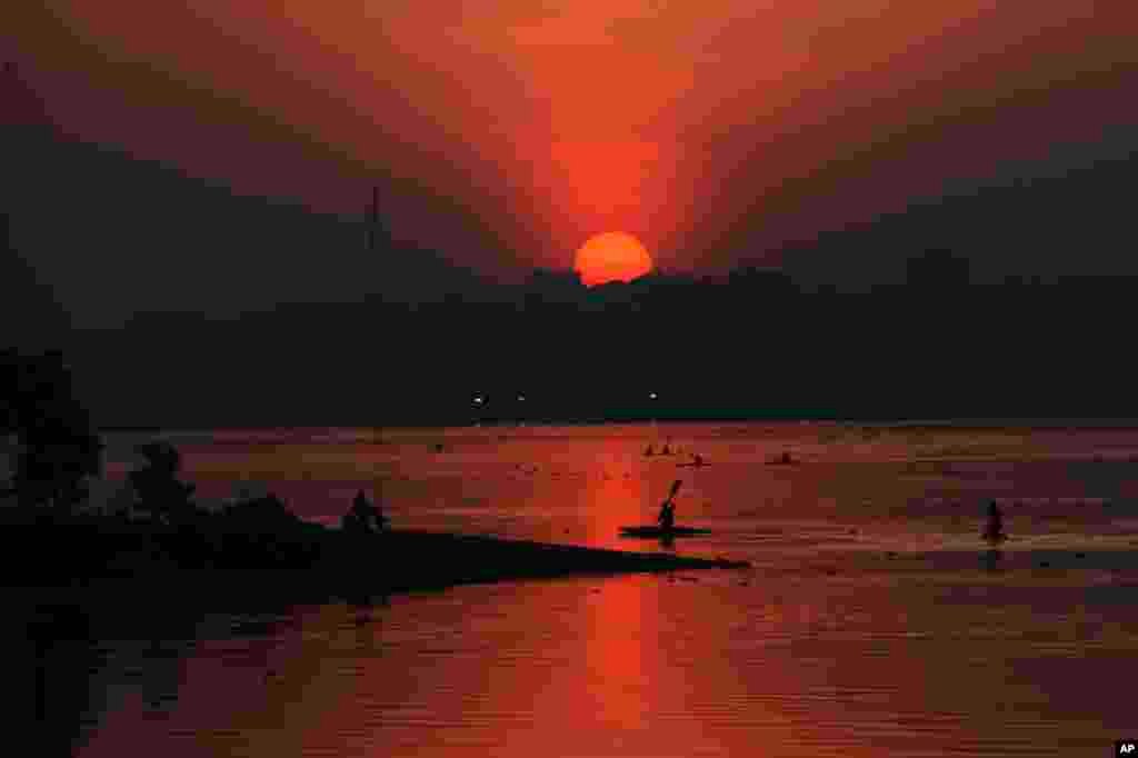 Indian sportsmen return to shore after canoeing practice as the sun sets at the Hussain Sagar Lake in Hyderabad, India.