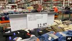 FILE: A sign displays the price for shirts at a Costco warehouse in this photograph taken Thursday, June 17, 2021, in Lone Tree, Colo. When wholesale prices rise, retailers raise theirs, impacting consumers. 