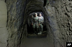 FILE - Afghan Special Forces inspect a cave which was used by suspected Islamic State militants at the site where a MOAB, or ''mother of all bombs'', struck the Achin district of the eastern province of Nangarhar, Afghanistan, April 23, 2017.