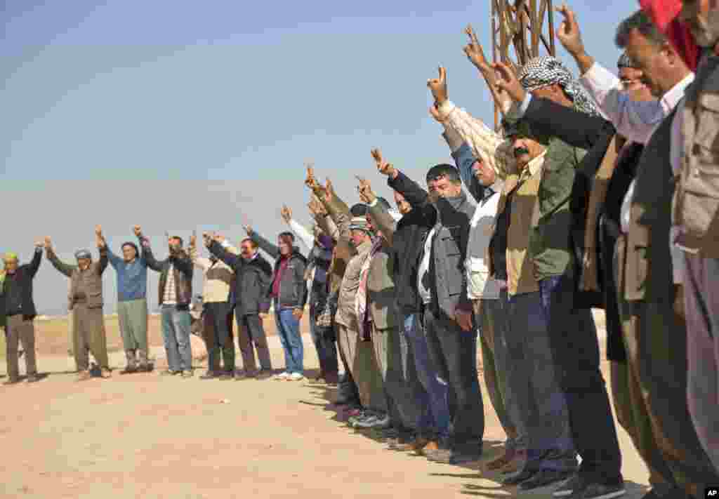 Kurds flash victory signs during a solidarity rally with the Syrian city of Kobani in the village of Caykara, Turkey, Nov. 11, 2014.