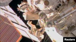 FILE - Two Russian cosmonauts are seen working outside the International Space Station during a spacewalk in this still image taken from NASA handout video, August 16, 2013.