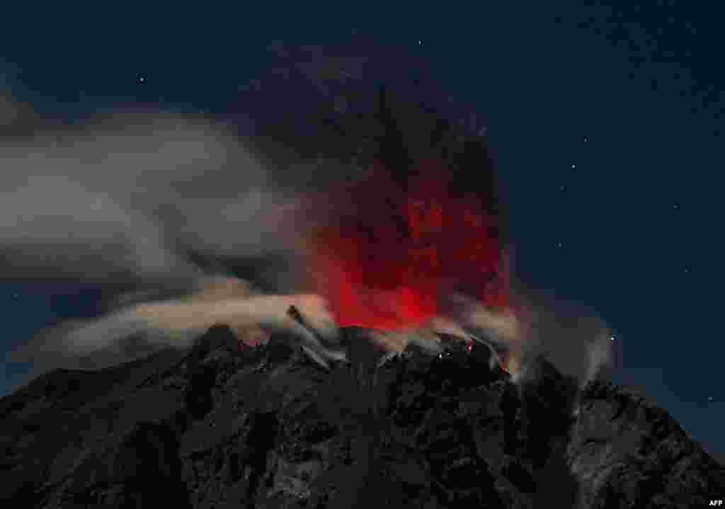 Mount Sinabung volcano spews reddish smoke and ash, as seen from the Karo district in North Sumatra province, Indonesia.