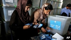 Afghan election commission workers sorts ballot papers for an audit of the presidential run-off votes at a election commission office in Kabul, July 18, 2014. 