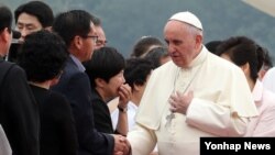 14일 한국 서울공항에 도착한 프란치스코 교황이 환영나온 인사들 중 세월호 유가족 대표들과 인사하며 위로의 말을 전하고 있다.
