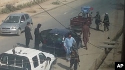 Taliban fighters search passengers and civilian vehicles in a check point in Kunduz city, north of Kabul, Afghanistan, Sept. 29, 2015. 